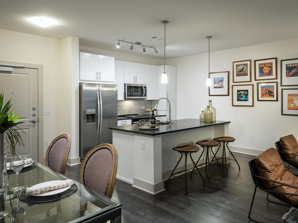 A modern kitchen and dining table with a kitchen island at the Cirro King of Prussia Apartments in Philadelphia Pennsylvania.